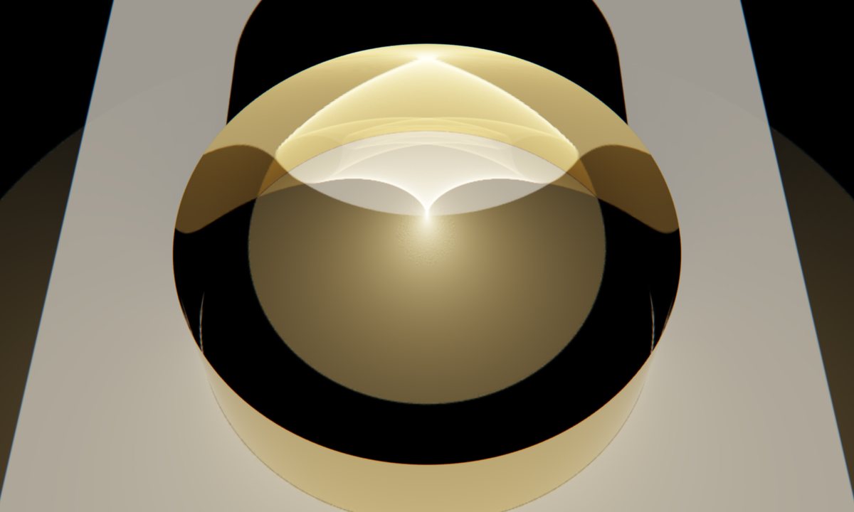 A gold ring standing on a pale table, seen from above. Inside it, reflected light forms a bright curve that meets in a sharp point.